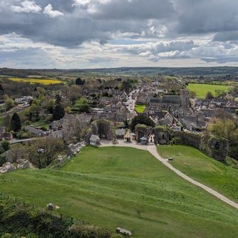 Photograph showing far reaching views of the village of Corfe Castle, the Purbeck hills from the castle grounds